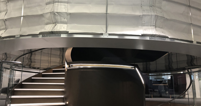 Coopers Fire FireMaster Concertina Closed Fire curtain over a central spiral staircase in London office