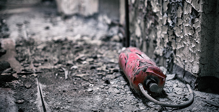 Burnt building with old fire extinguisher