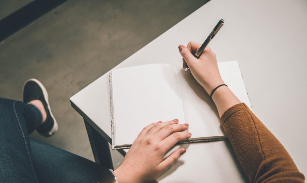 Person writing on blank paper