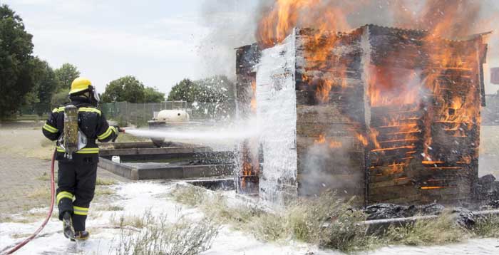 Firefighter putting out flaming shed