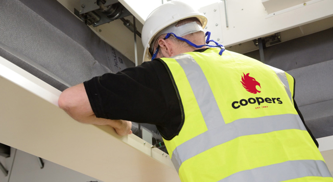 Coopers Fire Service Engineer fixing a FireMaster Concertina Fire Curtain