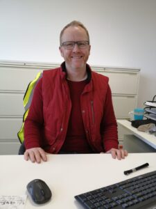 Man wearing all red sat at his desk