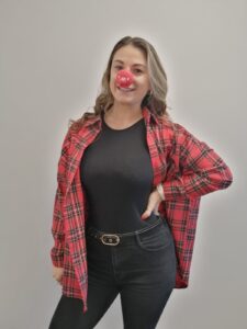Woman wearing a red shirt and red nose